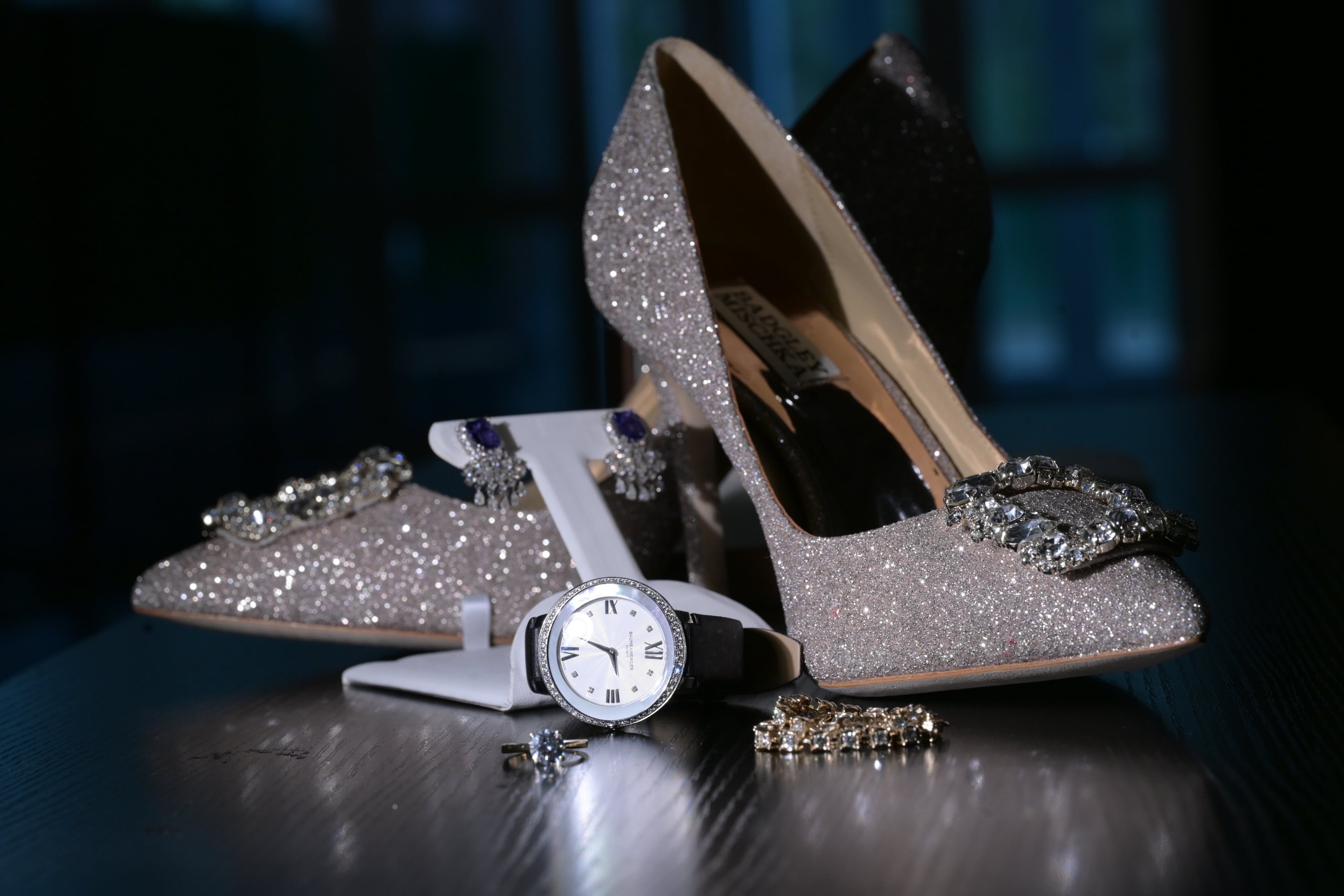 Flat lay of glittery heels, a watch, and bridal jewelry — composed like an album spread