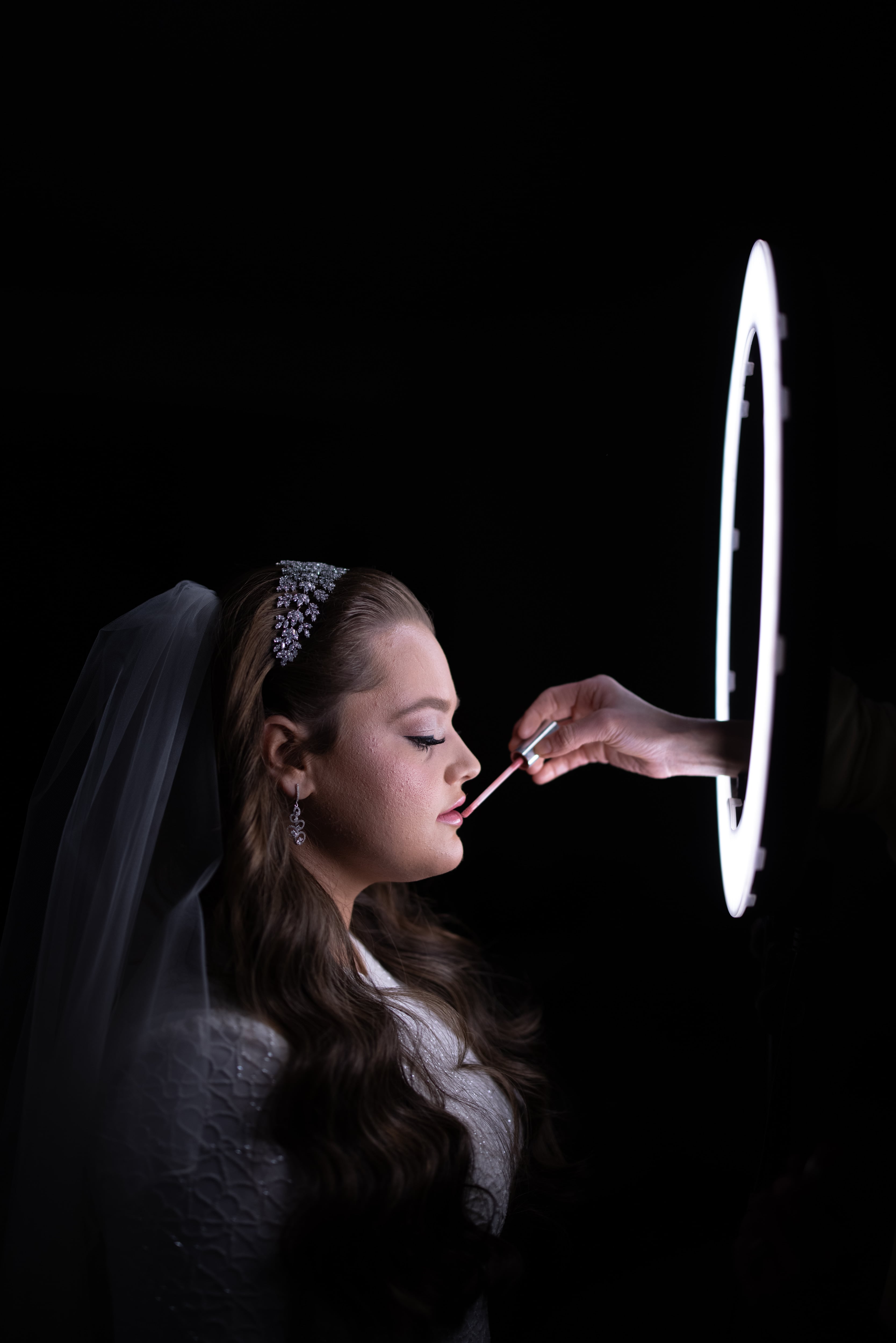 Bride having makeup applied at a mirrored vanity — Goldberg wedding