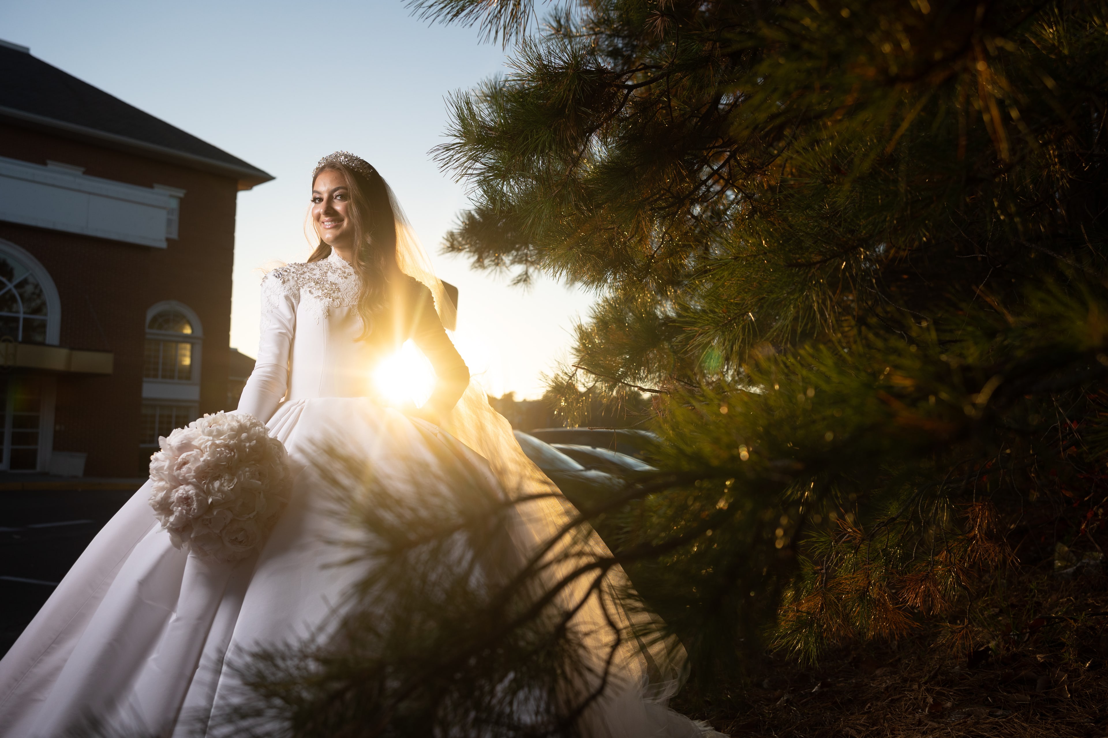 Bride at sunset by a pine tree — outdoor ceremony