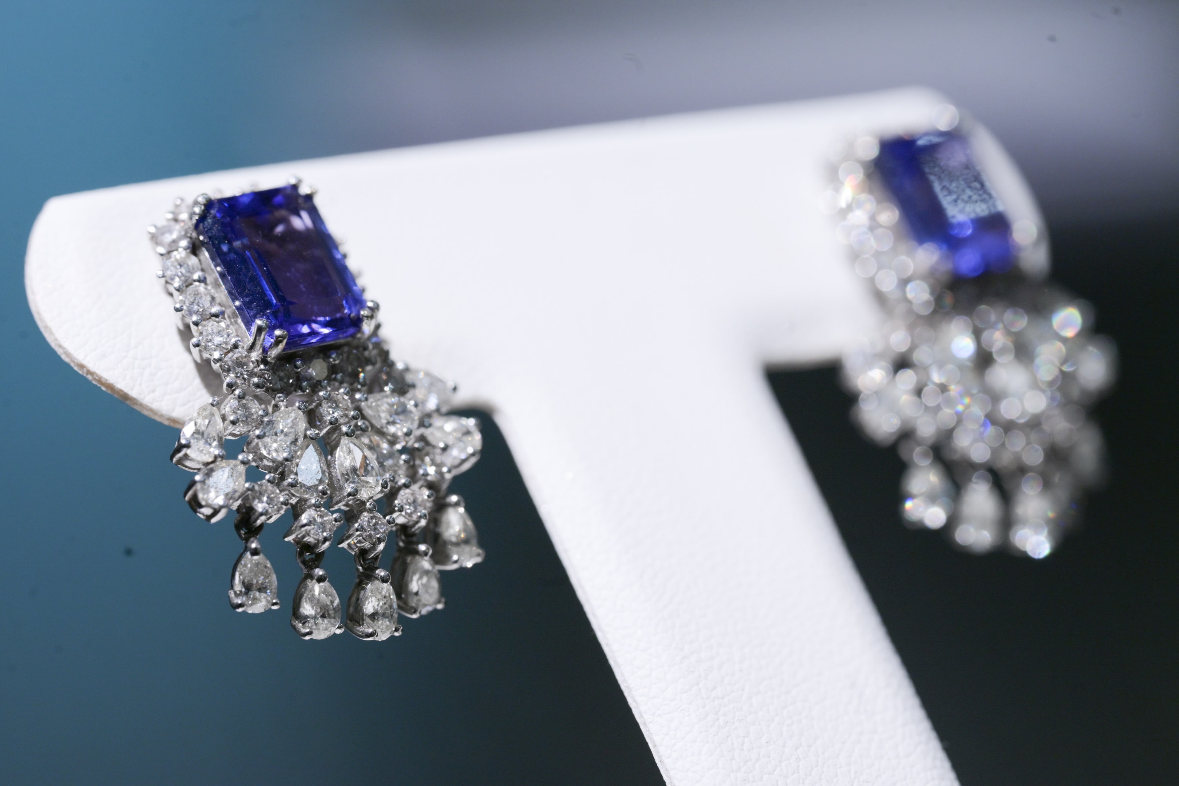 Tanzanite and diamond earrings on jeweler stand